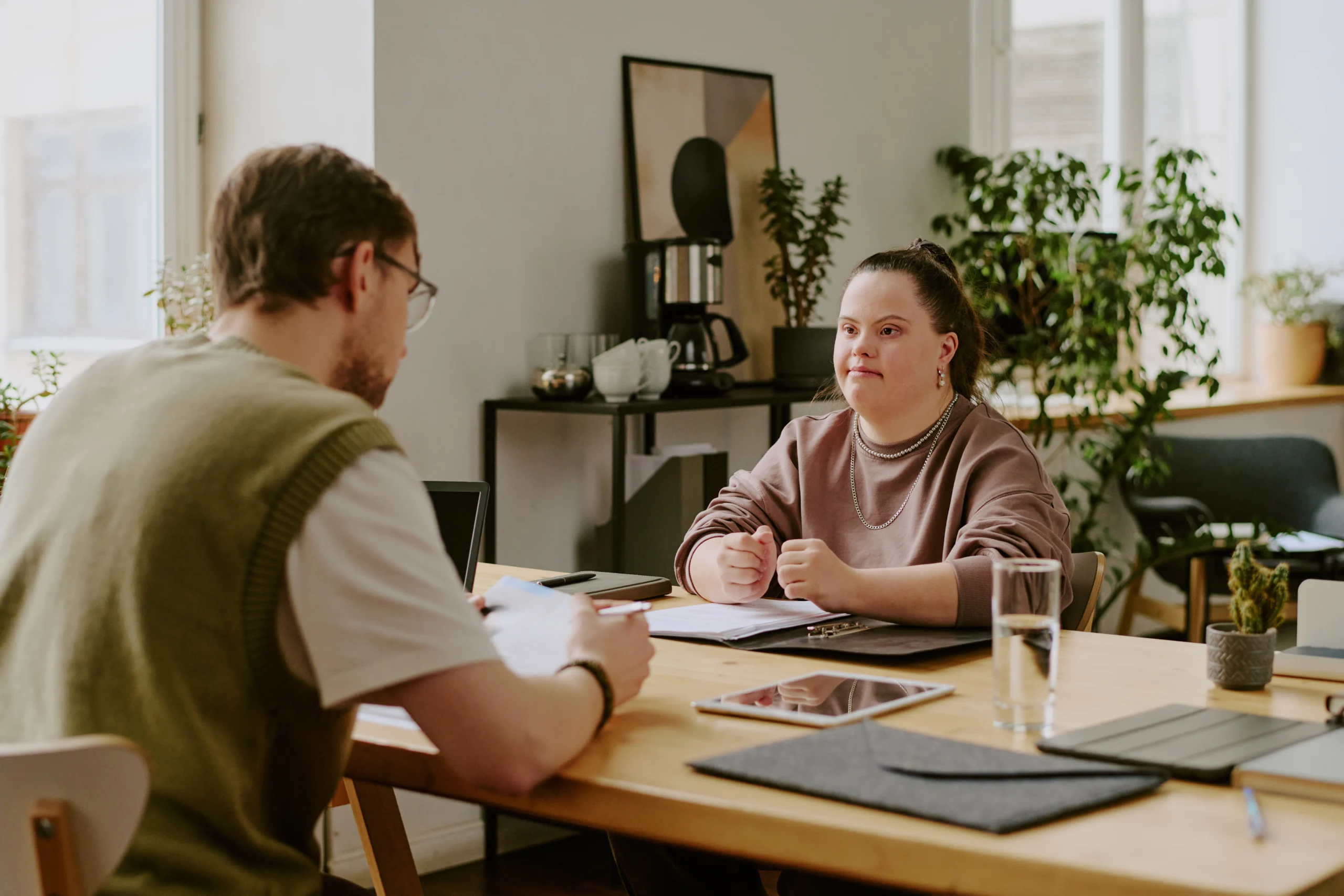 Job Interview in Office Medium shot of female candidate with down syndrome and male job interviewer sitting in front of each other while interacting