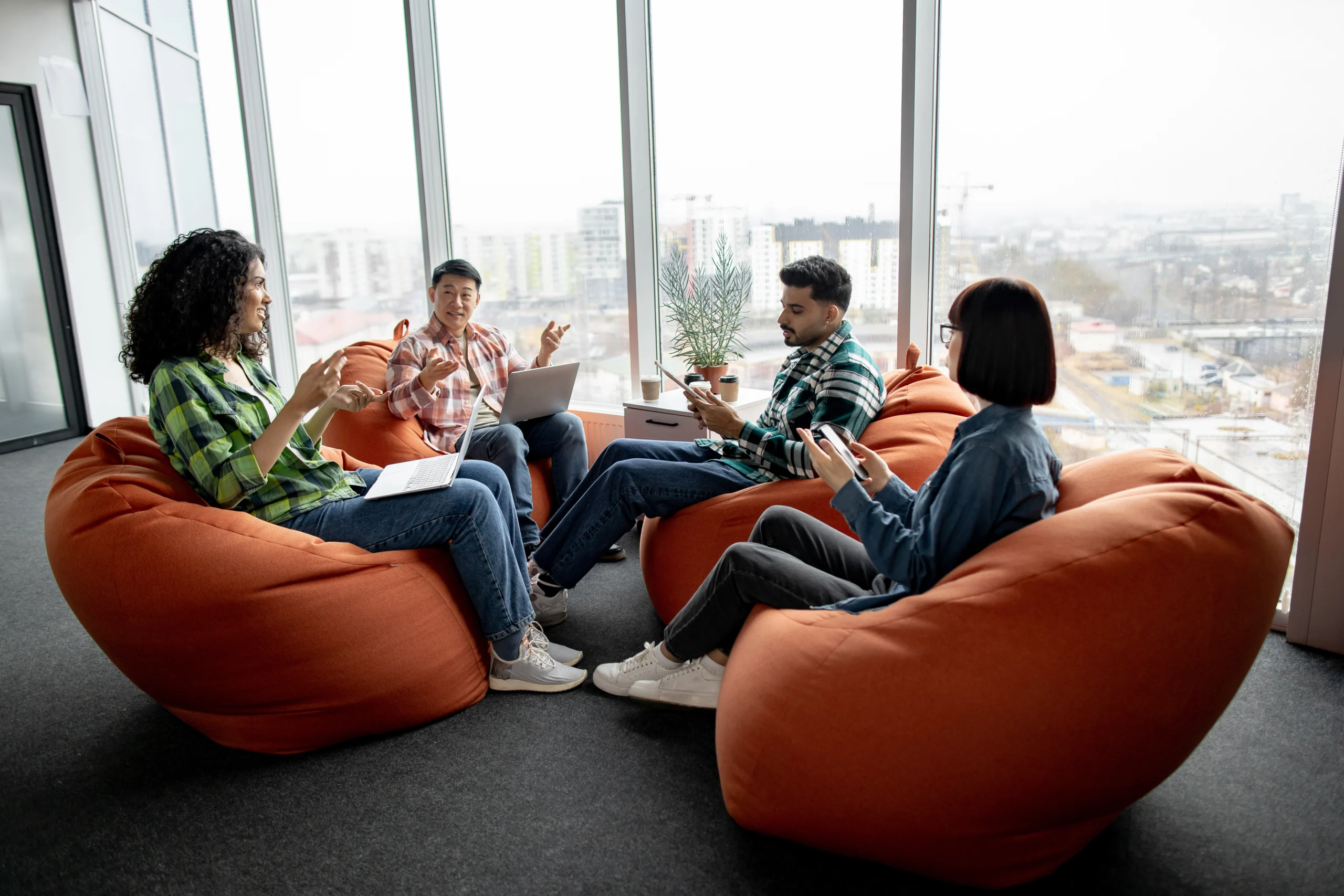 Colleagues discussing issues using devices in open office A group of work Colleagues discussing issues using devices in an open office.