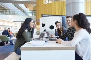 University students using laptops and digital tablet, working together